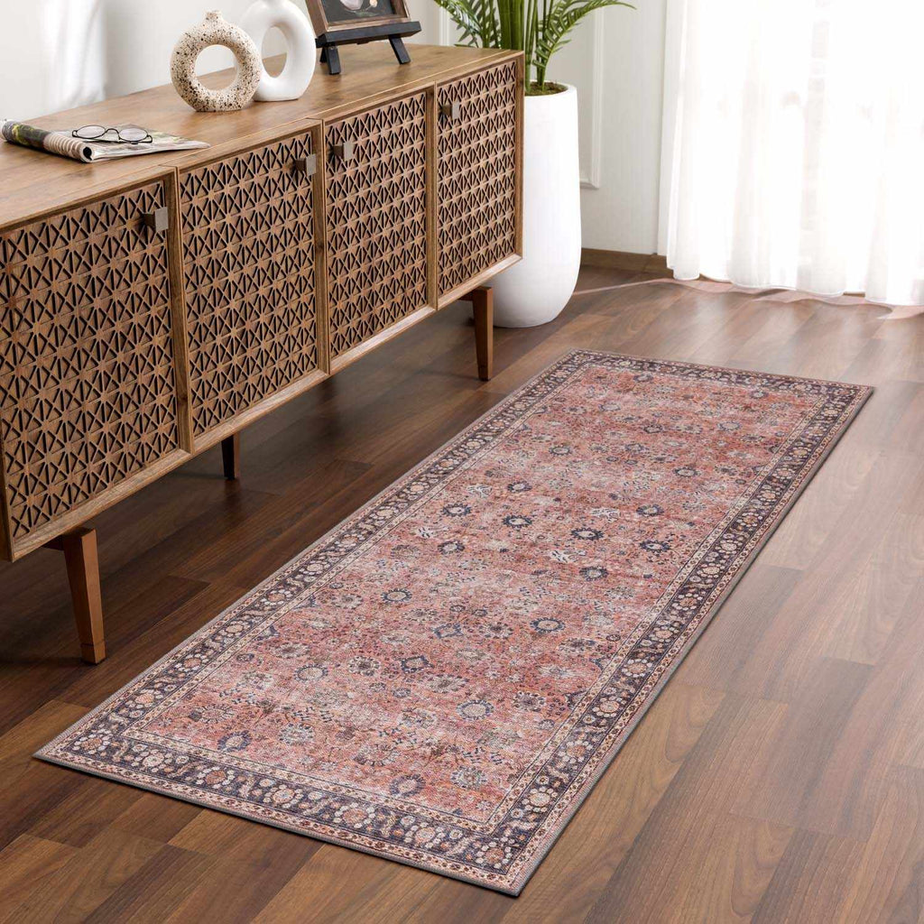 Long patterned rug on a wooden floor in a room with a wooden sideboard.