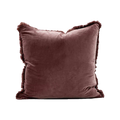 Brown velvet pillow with frayed edges on a white background