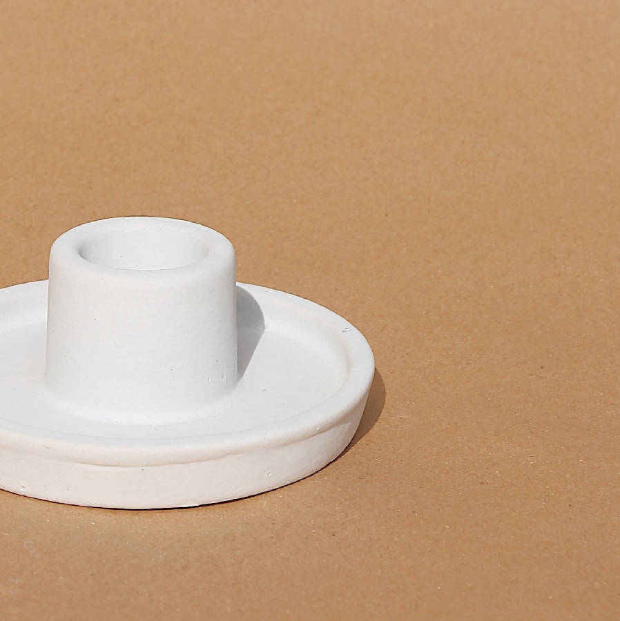 White ceramic candle holder on a brown background