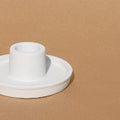 White ceramic candle holder on a brown background