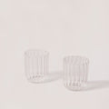 Two clear glass tumblers with ribbed design on a light gray background