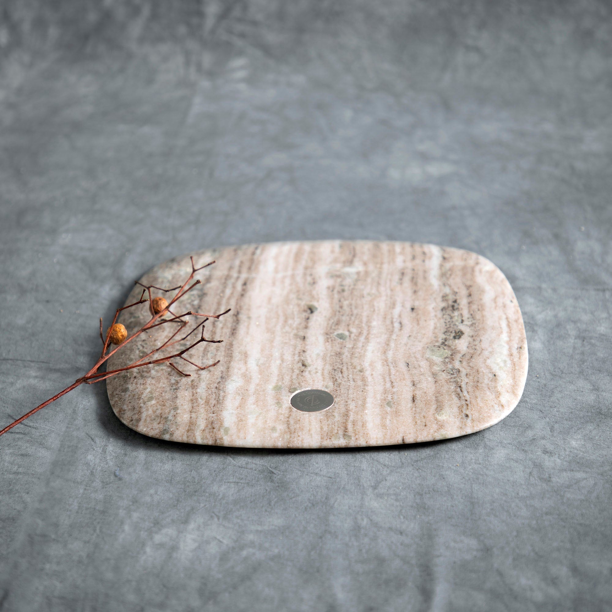 Marble cutting board with a small round hole on a gray surface
