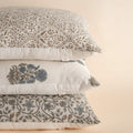 Stack of patterned pillows on a beige background