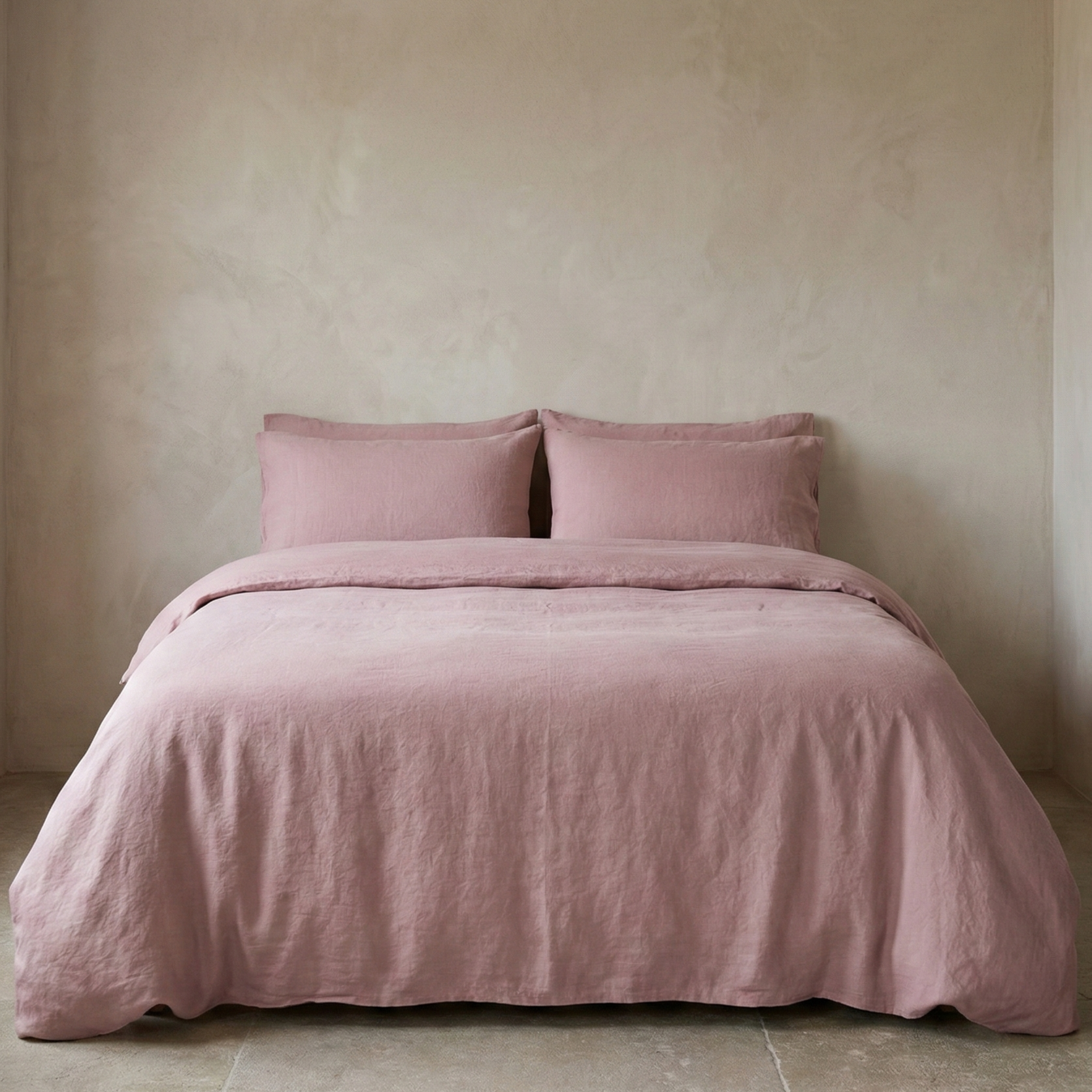 Pink bedding set on a bed against a beige wall
