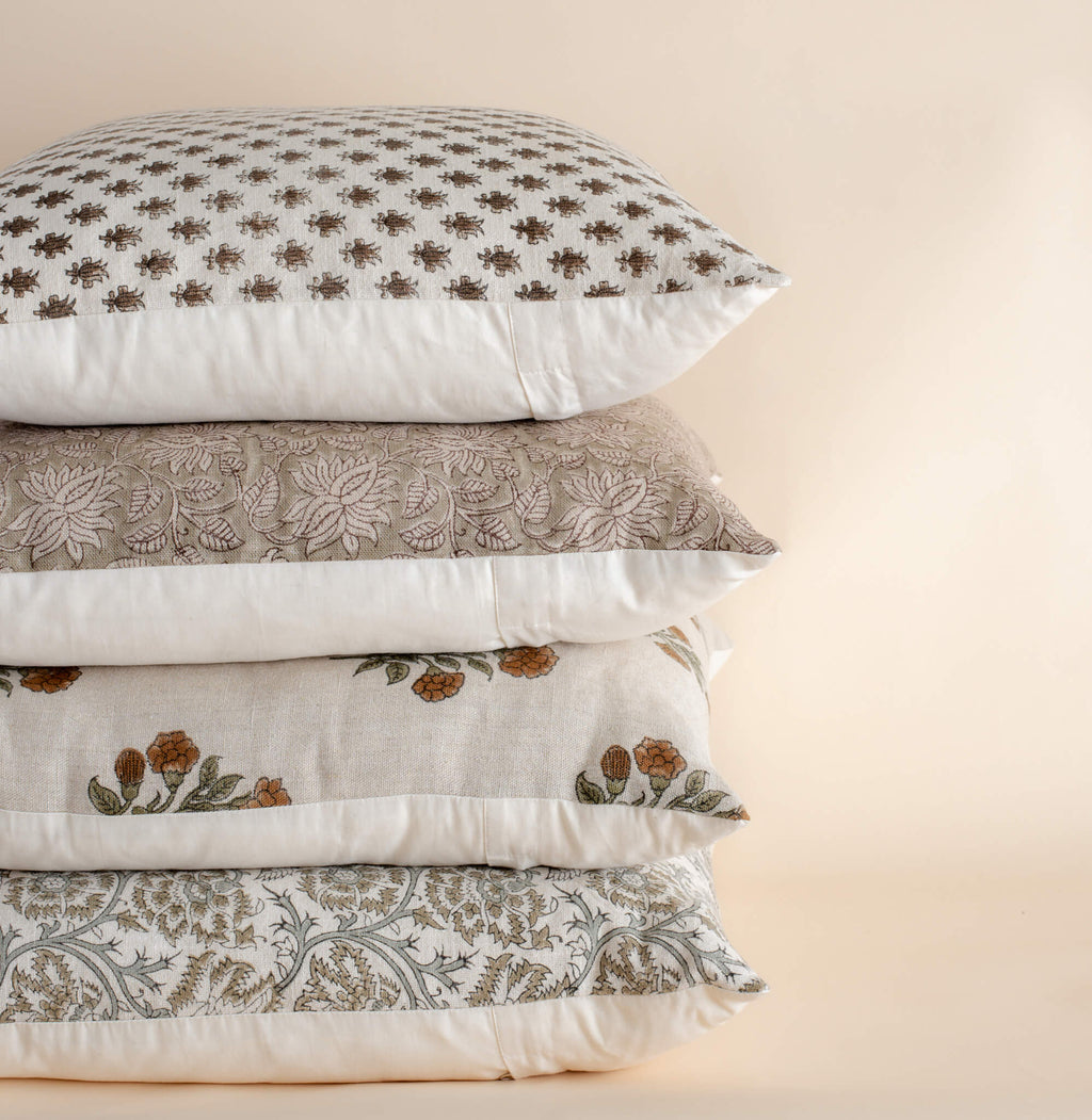 Stack of patterned pillows on a beige background