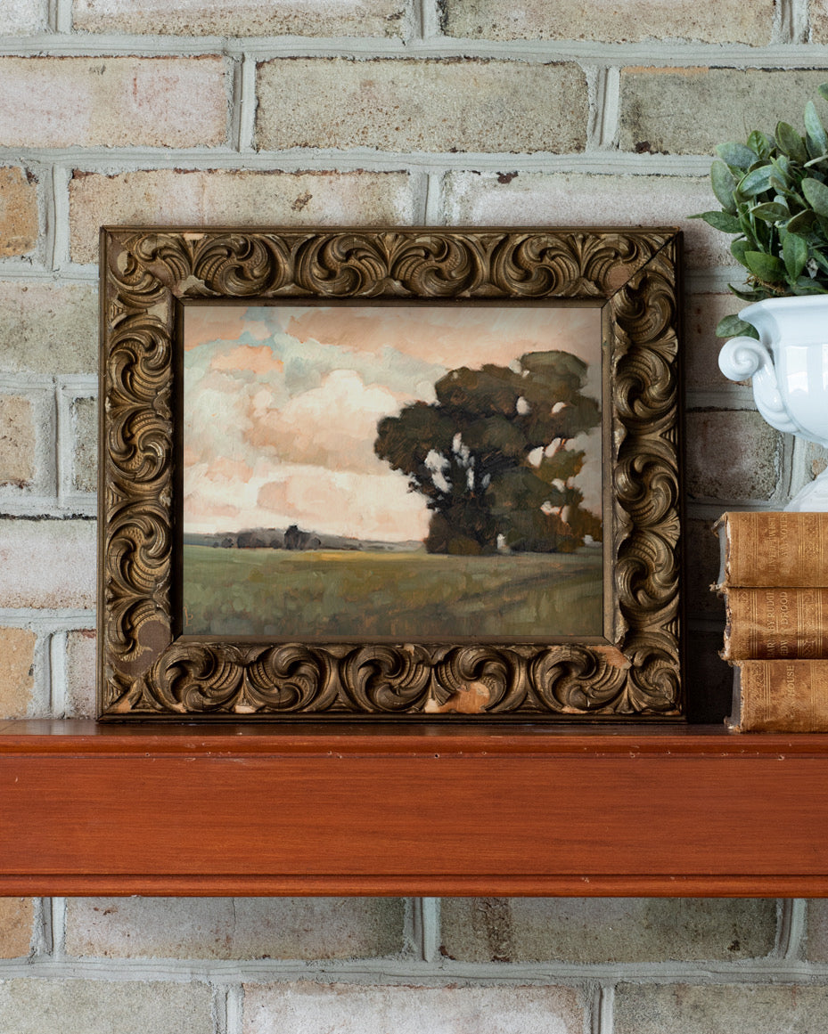Framed painting on a wooden surface with a brick wall background