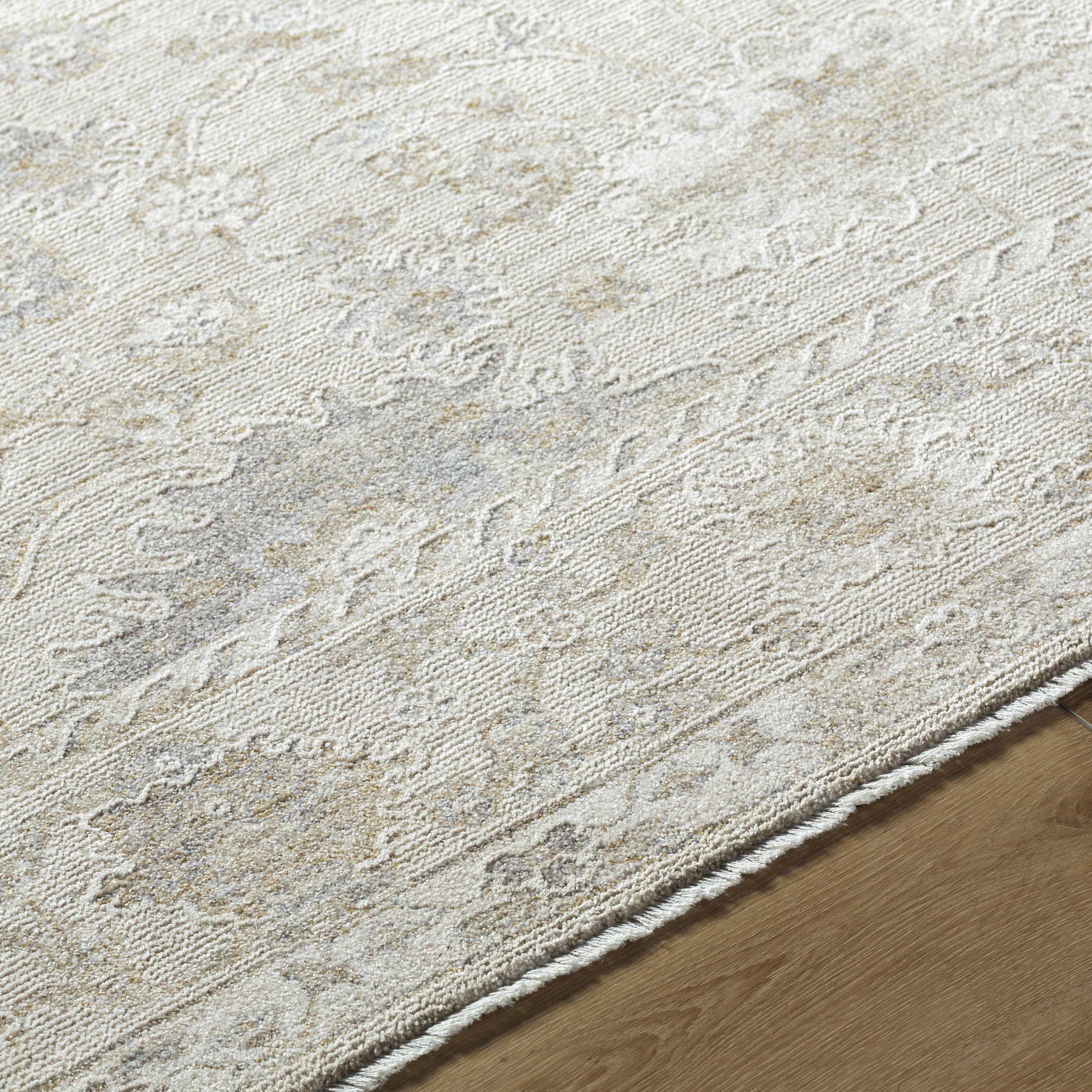 Close-up of a textured beige rug on a wooden floor